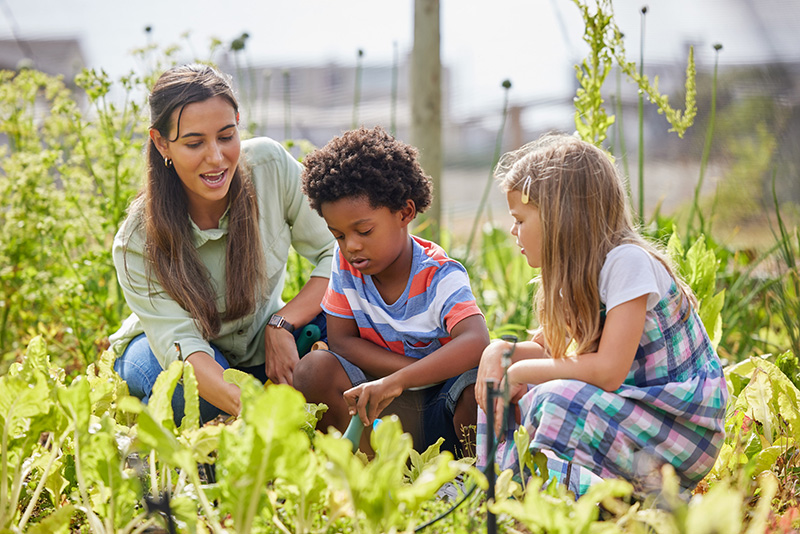 Teacher teaching students in a garden
